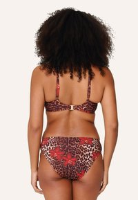 Costume da bagno leopardato marrone con vivaci dettagli floreali rossi. Presenta spalline regolabili e una chiusura dorata sul retro.