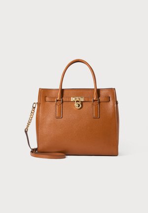 Bruine leren handtas met twee handvatten, een goudkleurig slotdetail aan de voorkant en een afneembare schouderriem met ketting.