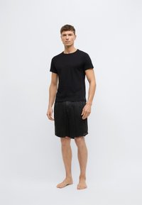 Μαύρο κοντομάνικο μπλουζάκι σε συνδυασμό με μαύρο σορτς. Απαλό ύφασμα, άνετη εφαρμογή και μονόχρωμο χωρίς σχέδια ή διακοσμητικά στοιχεία.