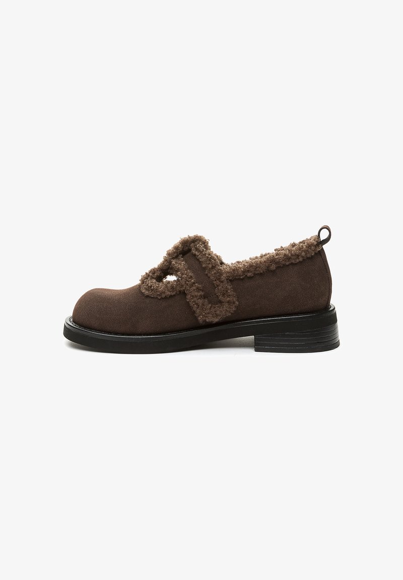 Scarpa Mary Jane in suede marrone con rifiniture in peluche, punta tonda, suola bassa nera e chiusura con strap regolabile, vista laterale su sfondo bianco.