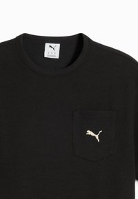 Sort waffle-strikket t-shirt med rund hals, der har en lille brystlomme og et hvidt Puma-logo broderet på lommen.