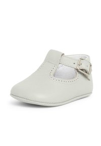 Zapato Mary Jane de cuero en gris claro con punta redonda, detalle perforado y cierre de hebilla lateral. Textura suave con bordes cosidos a mano.