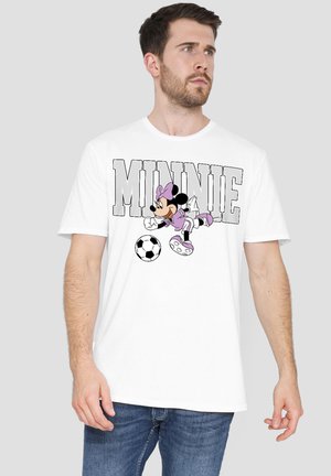 Man wearing white T-shirt with large "MINNIE" text and Minnie Mouse kicking a soccer ball in purple outfit on front.
