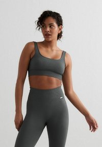 Grijze geribbelde sportbeha en high-waisted leggings, met een rekbare, textuurstof met een subtiele glans en minimale merknamen.