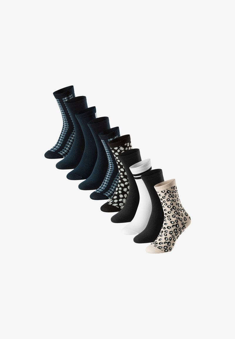Nove paia di calzini a metà polpaccio in nero, bianco e beige con motivi che includono righe, stampa leopardata e design geometrici.