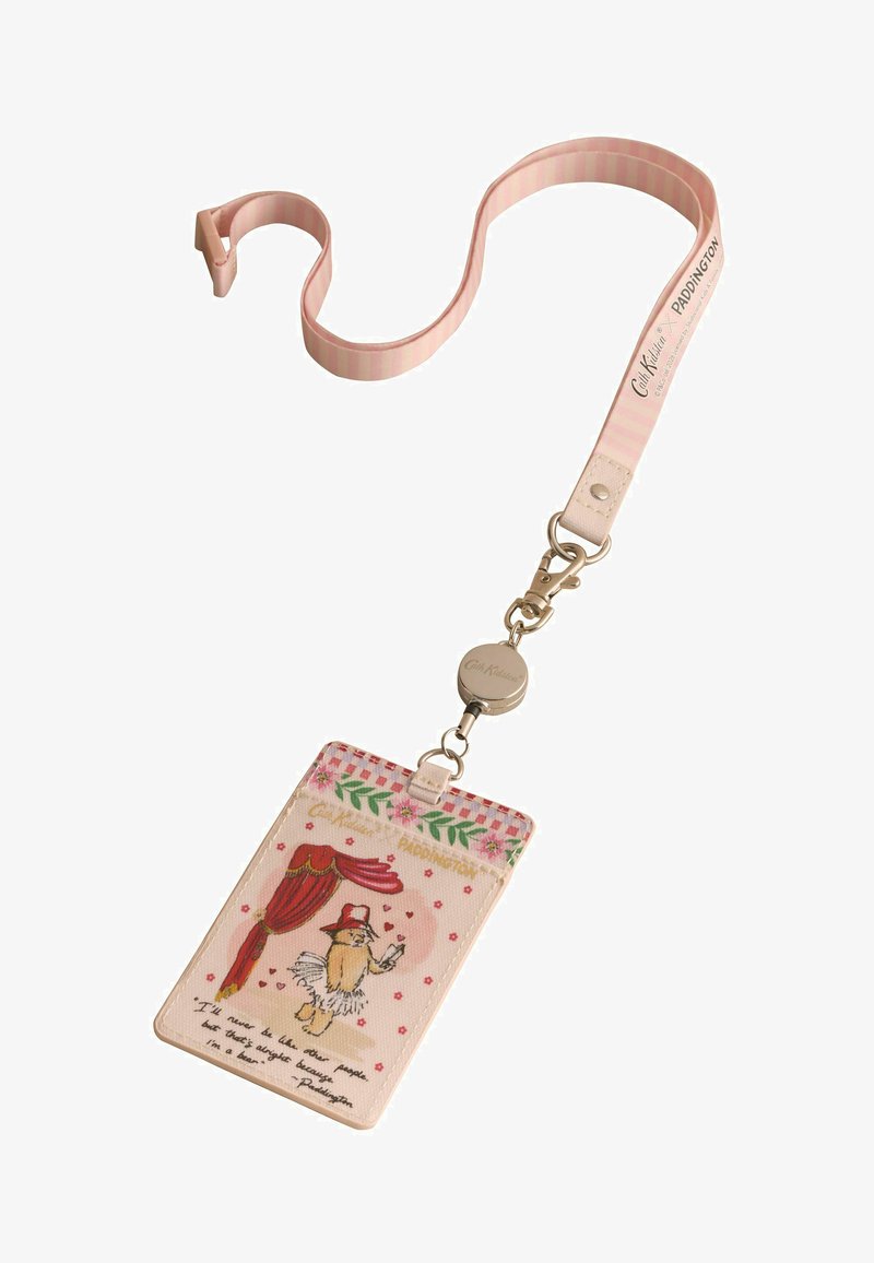 Lanière rose avec porte-badge rétractable et carte représentant Paddington Bear portant un chapeau et un tutu, avec une citation et une bordure florale décorative.