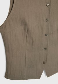 Gilet taupe sans manches avec cinq boutons sur le devant et un ourlet pointu au centre en bas.