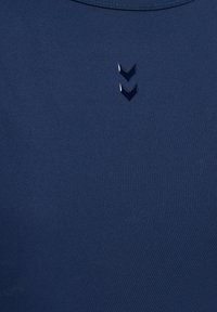 Navyblaue Sportshirt mit glatter Textur und drei chevronförmigen Akzenten in einer kontrastierenden Farbe am Halsausschnitt.