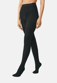 Svarta ribbade leggings med hög midja, med ett strukturerat mönster och en åtsittande passform från midja till anklar, tillverkade av ett stretchigt material.