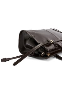 Bolso de mano de cuero marrón con textura suave y un brillo sutil, que presenta un diseño plano, correa ajustable y detalles en metal dorado.