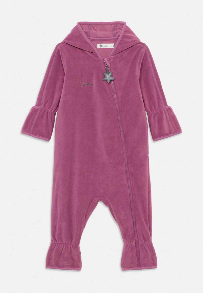 Paarse velours onesie met een capuchon, klokmouwen en een rits aan de voorkant met een stervormige ritstrekker. Geborduurde tekst nabij de rits.