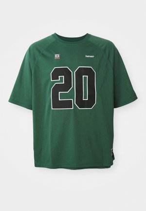 Žalia, trumpomis rankovėmis megzta marškinė su juodu numeriu "20" apvedžiotu baltai. Pasižymi apvaliu kaklu ir mažuoju logotipu kairėje viršuje.