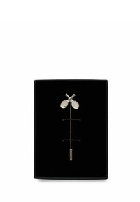 Guldbröstnål med två korslagda tennisklubbor, visad på svart bakgrund inuti en svart rektangulär låda.