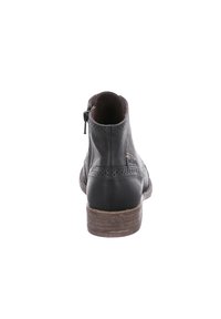Schwarze Leder-Stiefelette mit abgerundetem Absatz, Broguemuster am oberen Teil und einem seitlichen Reißverschluss zum Schließen. Holzstrukturierter Absatz.