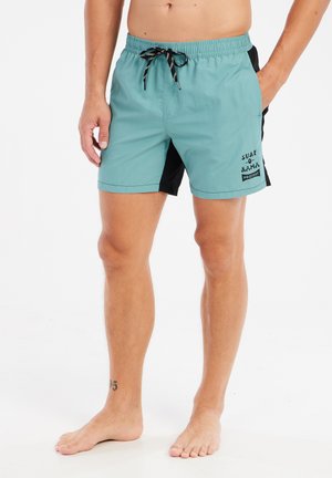 Shorts de bain turquoise et noirs avec un waistband élastique, cordon de serrage et logo imprimé. Tissu léger, coupe jusqu'aux genoux et design simple.