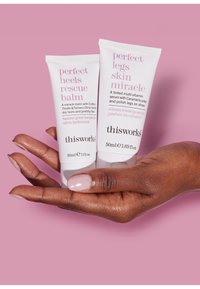 To hvide tuber med hudplejeprodukter holdt i en hånd. Den venstre tube, "Perfect Heels Rescue Balm" (30ml), og den højre, "Perfect Legs Skin Miracle" (50ml).