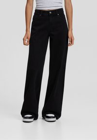 Mustat leveälahkeiset farkut kest�ävästä denimistä, joissa on korkea vyötärö, etutaskut ja klassinen nappisulku. Sujuva pinta ja vähäiset ompeleet.