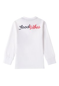 Weißes Langarmshirt mit "Good Vibes" in Schwarz und Rot auf dem Rücken gestickt. Rippbündchen und Rundhalsausschnitt. Aus weichem Baumwollstoff.