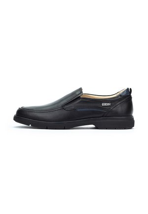 Zapatos negros sin cordones con exterior de cuero suave, acentos en azul marino, suela de goma y paneles laterales elásticos para un fácil calzado.