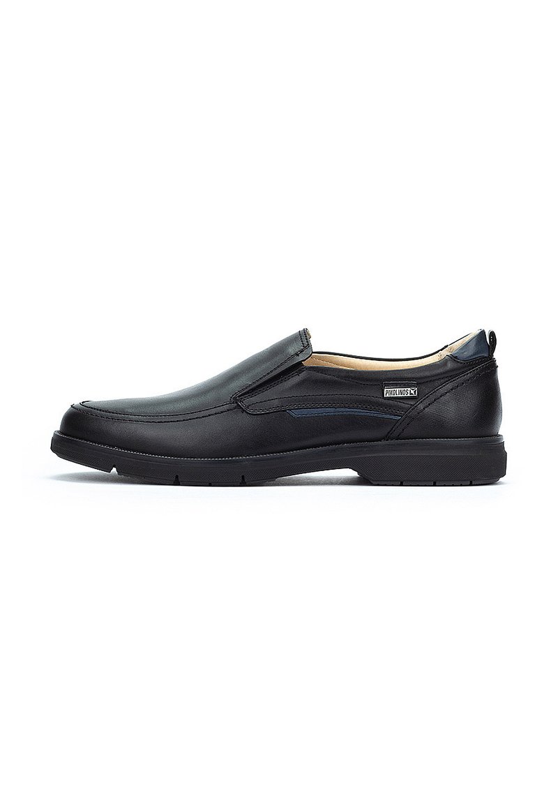 Zapatos negros sin cordones con exterior de cuero suave, acentos en azul marino, suela de goma y paneles laterales elásticos para un fácil calzado.