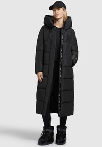 Schwarze Daunenjacke mit langem, strukturiertem Design, verstellbarer Kapuze und Reißverschluss-Front, mit horizontalen Steppabschnitten und Branding-Details.