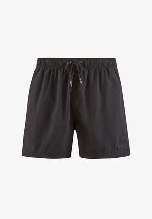 Black swim shorts feature an elastic waistband with drawstring. Smooth texture with a logo accent. Classic trunk style, knee-length cut.