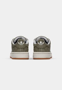 Zielone zamszowe trampki z białą podeszwą i gumową podeszwą. Tył posiada przeszycie oraz logo w jasnoszarym kolorze.