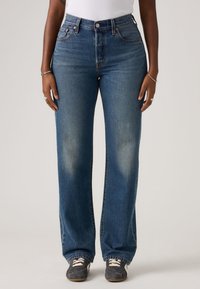 Τζιν μπλε χρώματος με υψηλή μέση και φαρδιά παντελόνια, με ελαφριά ξεθώριασμα, κλασικό σχεδιασμό με πέντε τσέπες και λεπτομέρειες από ασημένιο φερμουάρ. Μαλακή υφή denim.