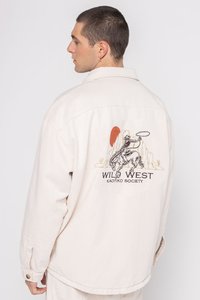 Beige denim jacket met geborduurd "WILD WEST" ontwerp, met een cowboy op een paard, en subtiele textuurstof.