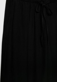 Pantalon taille élastique noire avec cordon de serrage, doté de poches latérales et d'une texture de tissu lisse et léger.