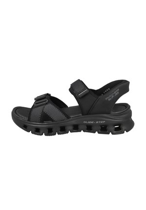 Chanclas negras con correas ajustables, parte superior texturizada, suela acolchada con perforaciones y la marca "GLIDE-STEP" en el lateral.
