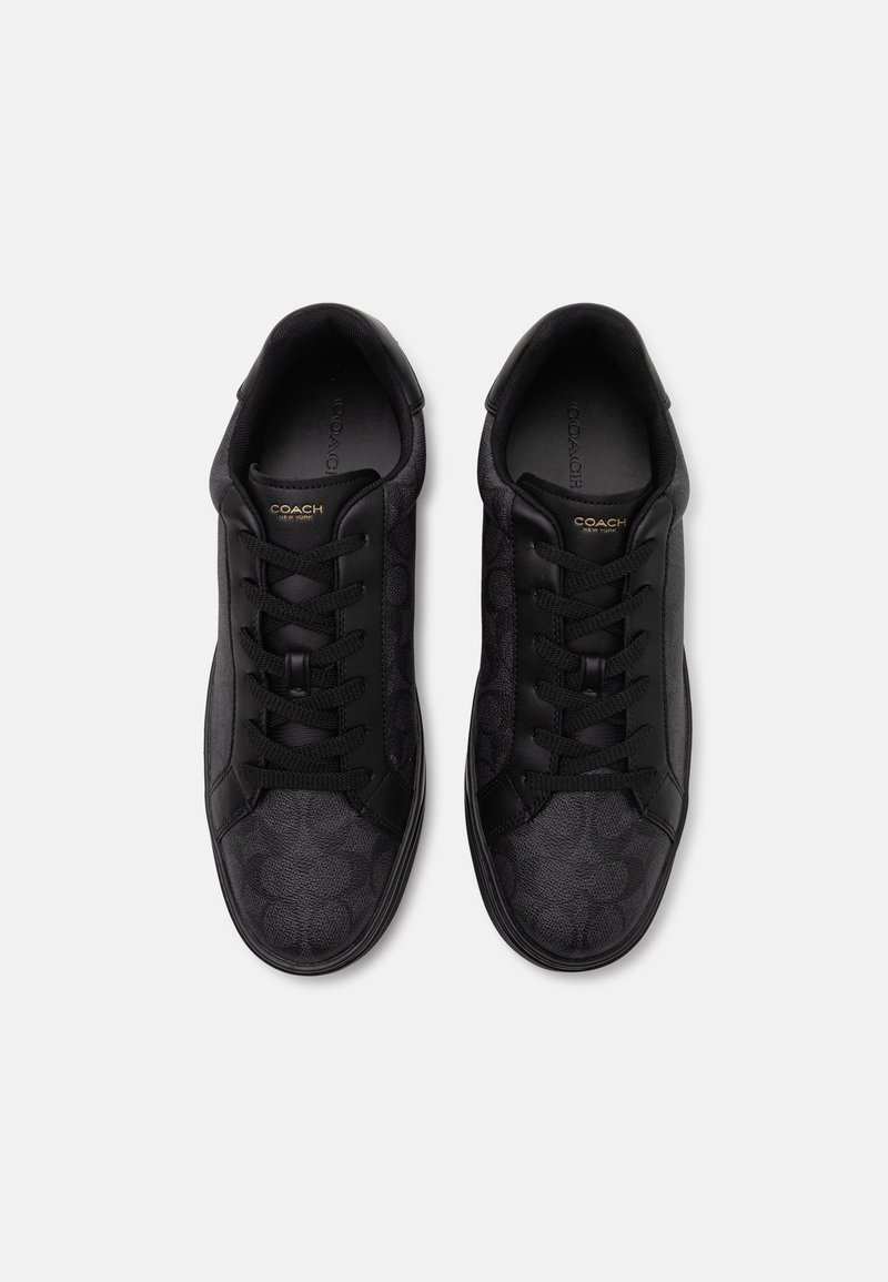 Schwarze Sneaker mit einem strukturierten Muster, ausgestattet mit schwarzen Schnürsenkeln und gestickten Akzenten. Coach-Logo in Gold auf der Zunge. Gummisohle.