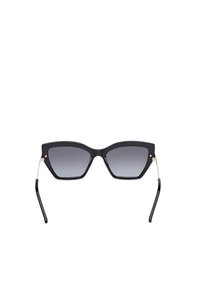 Gafas de sol angulares negras con lentes degradados, delgados acentos de metal dorado a los lados y montura de plástico negro brillante.