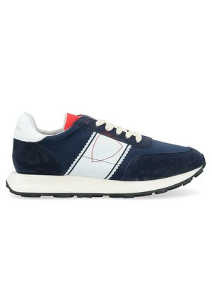 Scarpe da ginnastica navy e bianche con pannelli in suede, dotate di un design leggero, lacci crema e un accento rosso sul tallone.