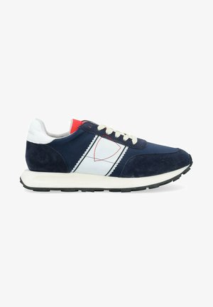 Scarpe da ginnastica navy e bianche con pannelli in suede, dotate di un design leggero, lacci crema e un accento rosso sul tallone.