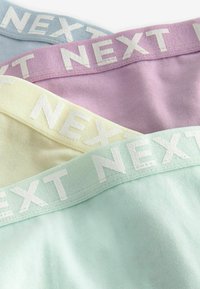 Drie paar gekleurde ondergoed met elastische banden in mintgroen, lavendel en pastelgeel, met reliëf "NEXT" logo's.