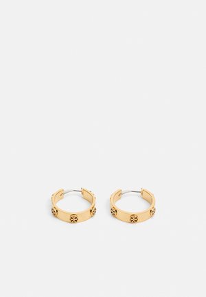 Pendientes de aro de color dorado con una superficie lisa y acentos circulares decorativos. El diseño presenta una forma redonda simple y un cierre de bisagra abierto.