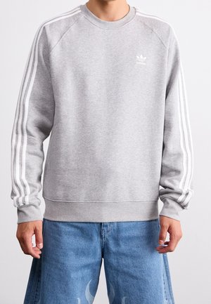Grijze sweatshirt gemaakt van een katoenmix, met witte driekleurige accenten langs de mouwen en een klein wit logo op de borst.