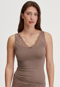 Top canna marrone con bordo in pizzo e un piccolo gancio centrale. Presenta un collo a giro e una silhouette aderente. Tessuto morbido e liscio.