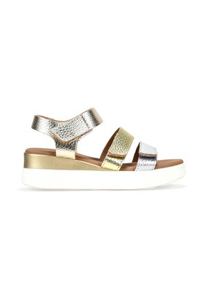 Sandalias de plataforma metálicas con tres tiras en acabados plateado, dorado y bronce. Cuentan con una gruesa suela blanca y una plantilla acolchada marrón.
