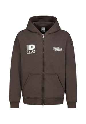 Bruine hoodie met rits en voorzakken, "DAILY SUBLEVEL" logo op de linkerborst en "Worldwide" tekst met wereldbol afbeelding op de rechterborst.