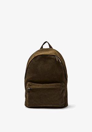 Donkerbruine suède rugzak met een voorvak met ritssluiting en een draaglus aan de bovenkant, afgebeeld tegen een witte achtergrond.