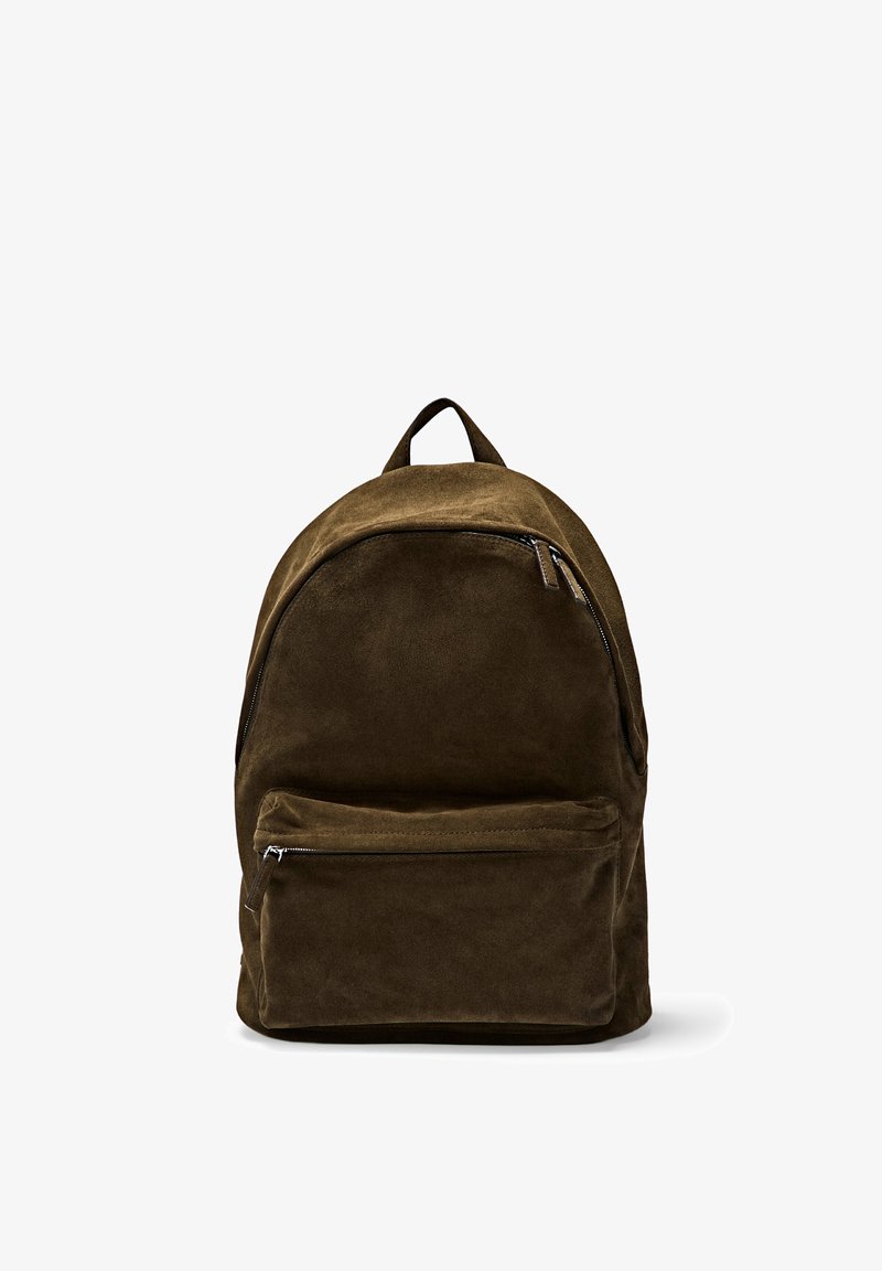 Sac à dos en daim marron foncé avec une poche avant zippée et une poignée de transport supérieure, présenté sur un fond blanc.