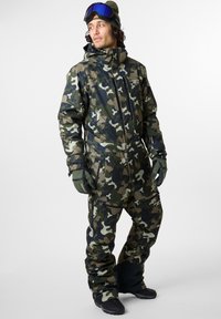 Kamuflasjepikse i nyanser av grønt, brunt og svart. Har høy krage, flere lommer og tettsittende mansjetter med hansker.