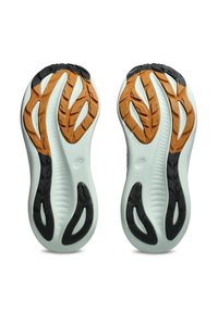 Ydersålerne på atletiske sko med hvid bund, sorte og orange skridsikre mønstre, vist side om side på en hvid baggrund.