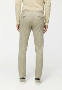 Világos bézs színű nadrág, finom függőleges csíkos mintával, testre szabott fazonnal, hátsó zsebekkel és sima felülettel.