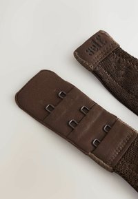 Bruine stoffen banden met gaasstructuur, voorzien van meerdere metalen lussen voor het bevestigen. Aan één uiteinde staat merkdruk in reliëf. Glad en stevig ontwerp.