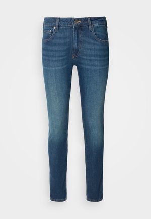 Jeans in denim blu scuro con una vestibilità attillata, caratterizzati da un classico design a cinque tasche, chiusura con bottone metallico e leggera sbiaditura sulle gambe.