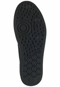 Suola in gomma nera con un motivo testurizzato, caratterizzata da design circolari e esagonali per una migliore aderenza e una leggera curvatura lungo il bordo.