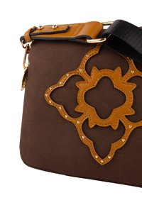 Borsa marrone con superficie testurizzata, dettagli in pelle color nocciola, intagli decorativi e borchie dorate, con attacco per tracolla nera.